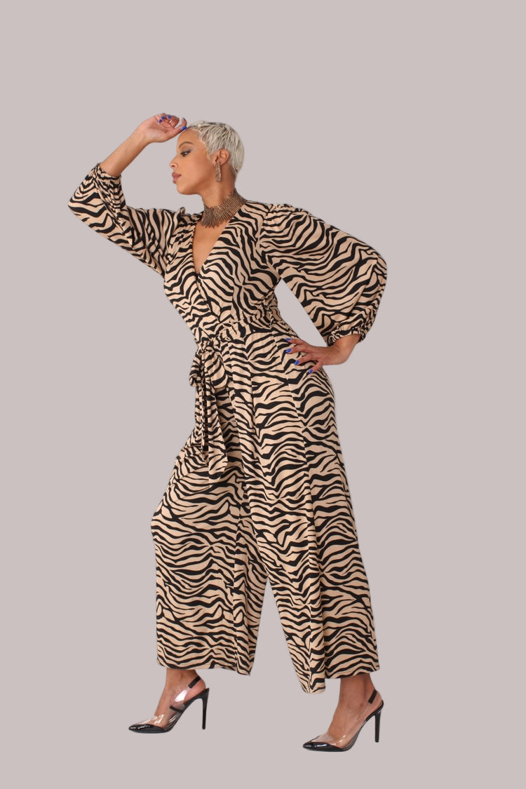 Model posing with arm bent wearing coffee and black wide-leg jumpsuit with puff sleeves by For Her NYC