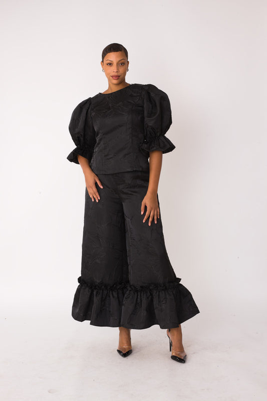 Midnight Drama ruffle set style 82375 in black shown from the front in a standing pose highlighting the jacquard texture, puff sleeves, and ruffle hem by For Her NYC