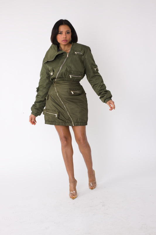 Model wearing olive cropped utility bomber jacket, front walking pose, For Her NYC