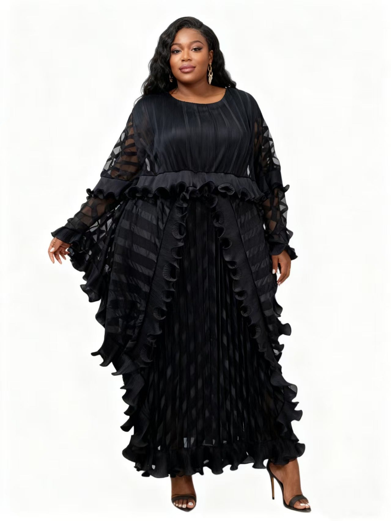 Model wearing a black pleated maxi dress with cascading ruffles and sheer striped sleeves, front view – For Her NYC 83024