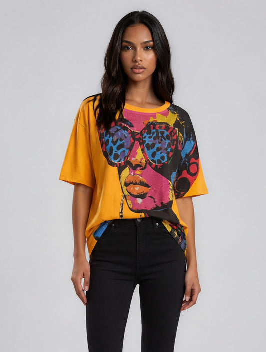 Woman wearing a vibrant oversized graphic tee featuring a colorful portrait print with embellished sunglasses and abstract art detailing – For Her NYC
