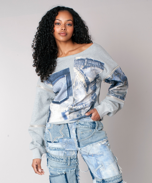 Woman wearing a grey off-shoulder sweatshirt with denim patchwork details, styled with distressed denim jeans, front view — For Her NYC