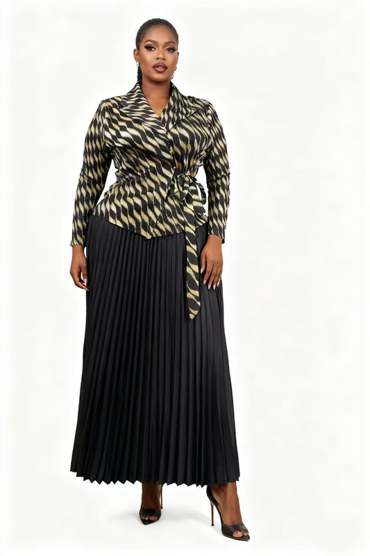 Woman wearing a black pleated midi skirt with a patterned wrap-style jacket featuring a tie waist, styled with heels — For Her NYC