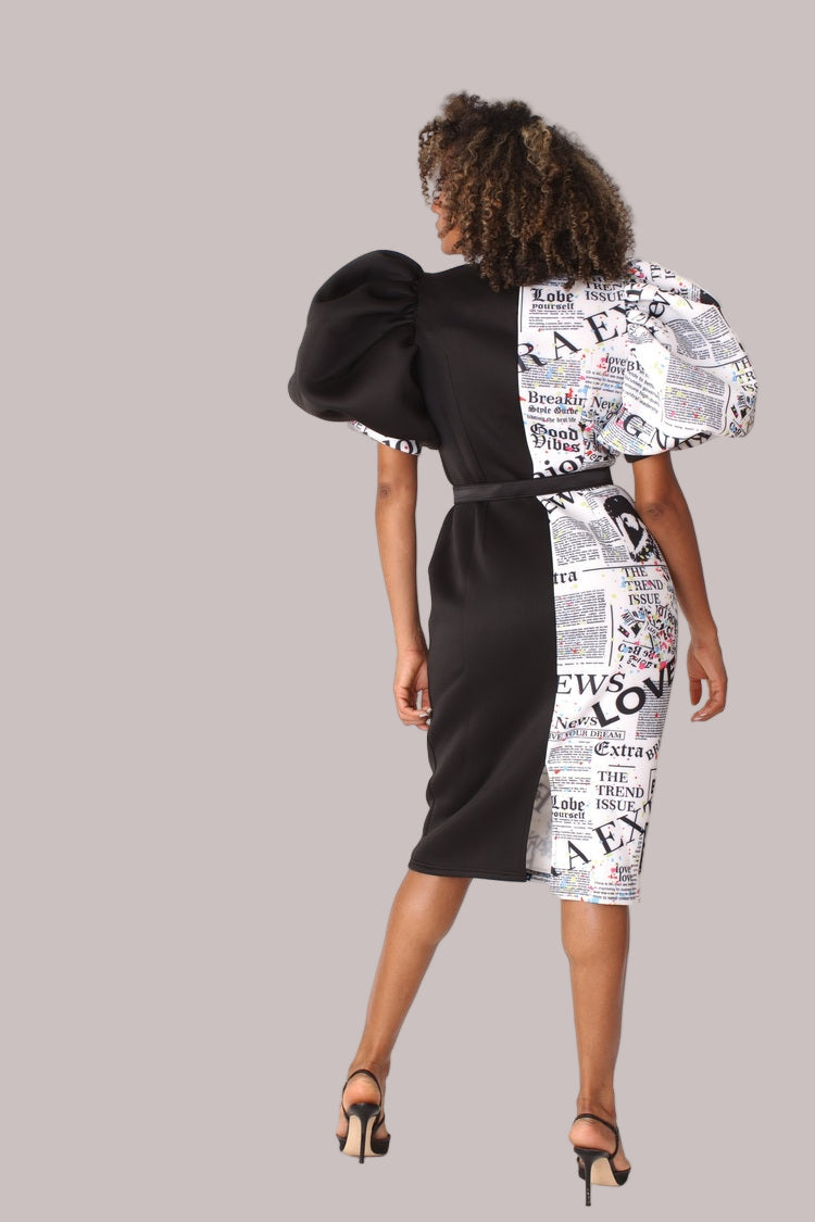 Model wearing black print puff sleeve midi dress with bow tie collar, full back view showcasing clean lines and bold print detailing by For Her NYC