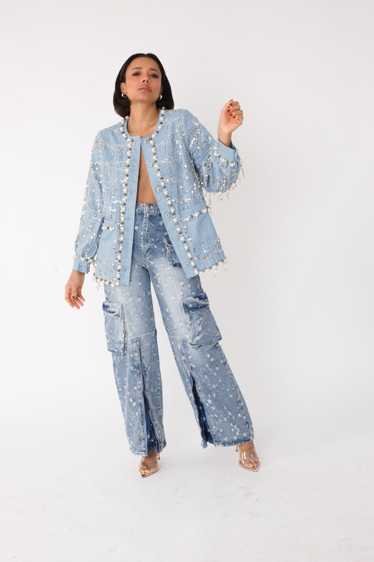 Blue denim jacket with sequins and pearl embellishments shown on model walking forward, front view, For Her NYC
