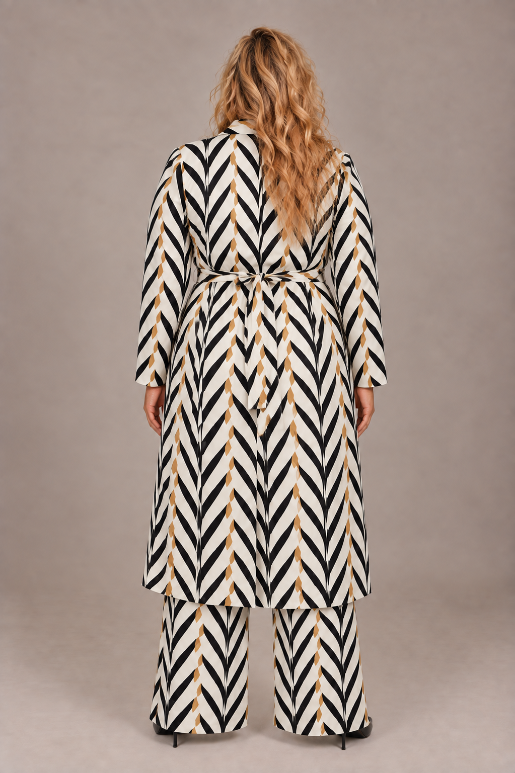 Back view of a plus-size model wearing the For Her NYC Plus Size Chic Chevron Print Duster Pant Set - S0271W in black, white, and tan with a belted duster and wide-leg pants