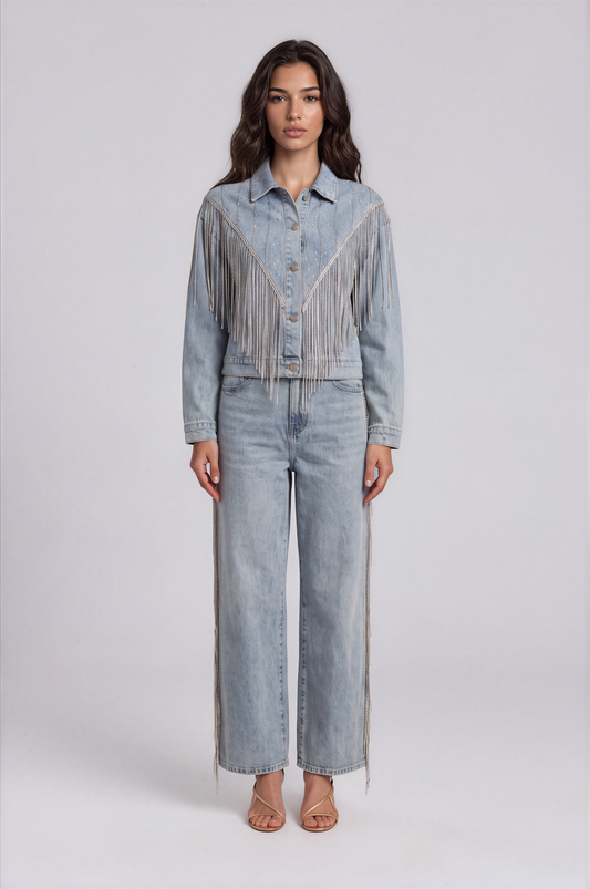 Front view of a model wearing the light-wash For Her NYC Rhinestone Fringe Denim Jacket - 82938 with a button front and cascading rhinestone fringe