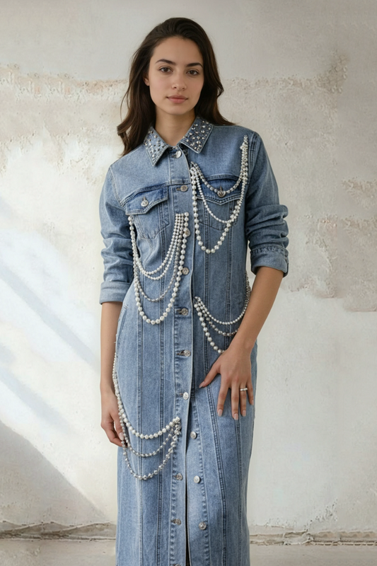 Model wearing pearl-embellished denim dress with chain details and button-front design by For Her NYC.