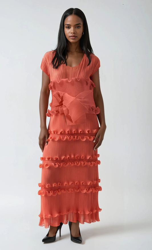 Model wearing orange ruffled pleated maxi dress with waist tie and tiered texture by For Her NYC.