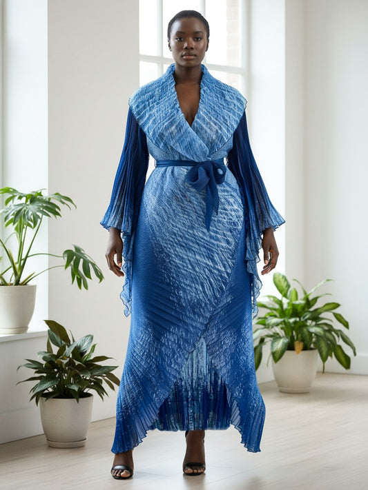 Front view of model wearing a blue pleated wrap dress with self-tie waist and long sleeves, For Her NYC