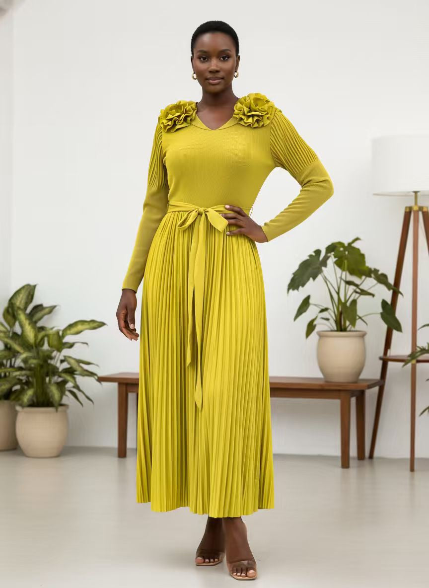 Green pleated midi dress with rosette shoulders and tie waist, model standing front in studio setting, For Her NYC