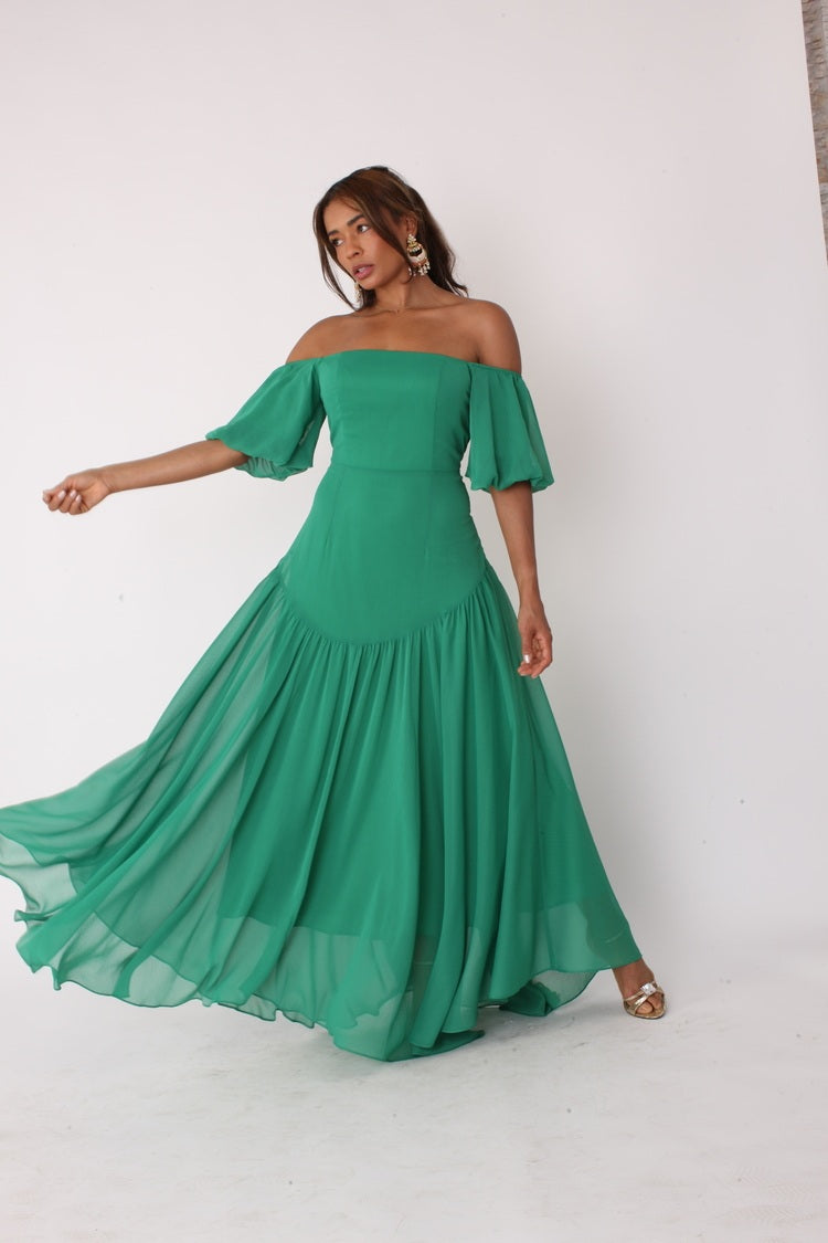 Emerald off-shoulder maxi dress shown in motion with skirt movement and dramatic flow, For Her NYC