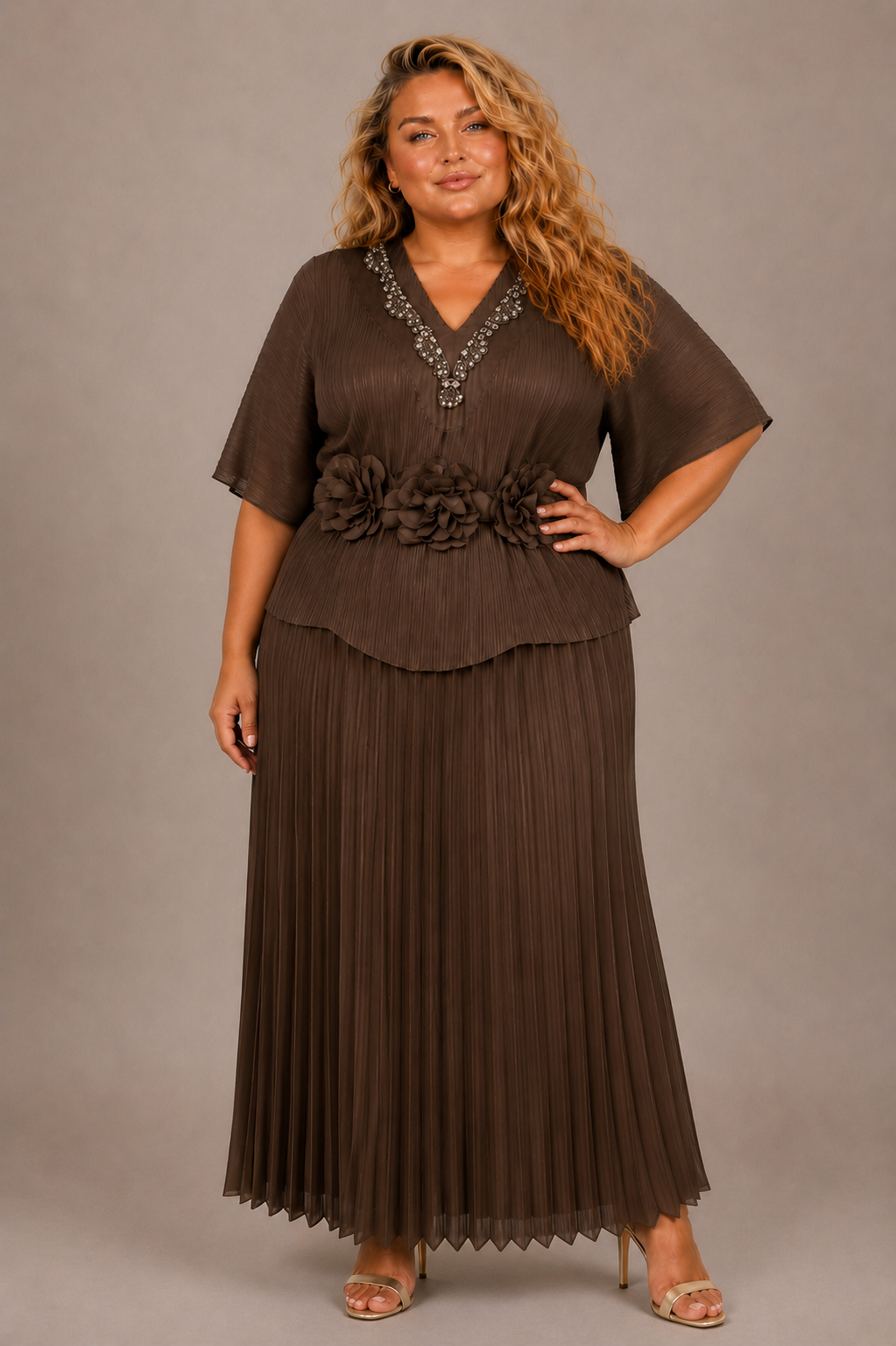 Plus size model wearing the Tally Taylor Embellished Pleated Midi Dress in brown, featuring a jeweled V-neckline, floral waist embellishments, and pleated skirt, style S0269W.