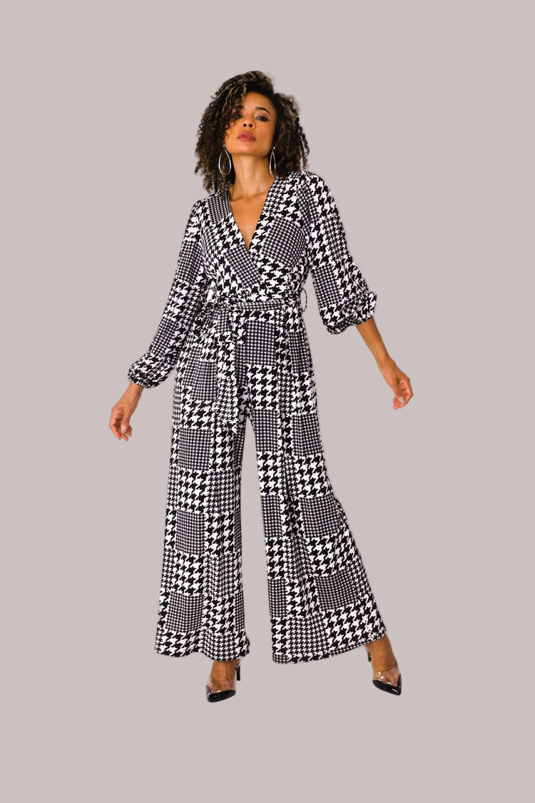 Model wearing houndstooth wide-leg jumpsuit with puff sleeves standing front-facing by For Her NYC