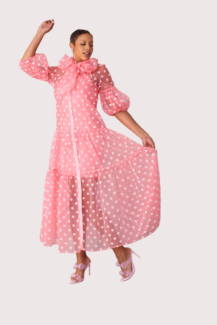 Polka dot organza maxi dress style 82234 in coral and white shown with arm movement highlighting sheer sleeves and tiered skirt by For Her NYC