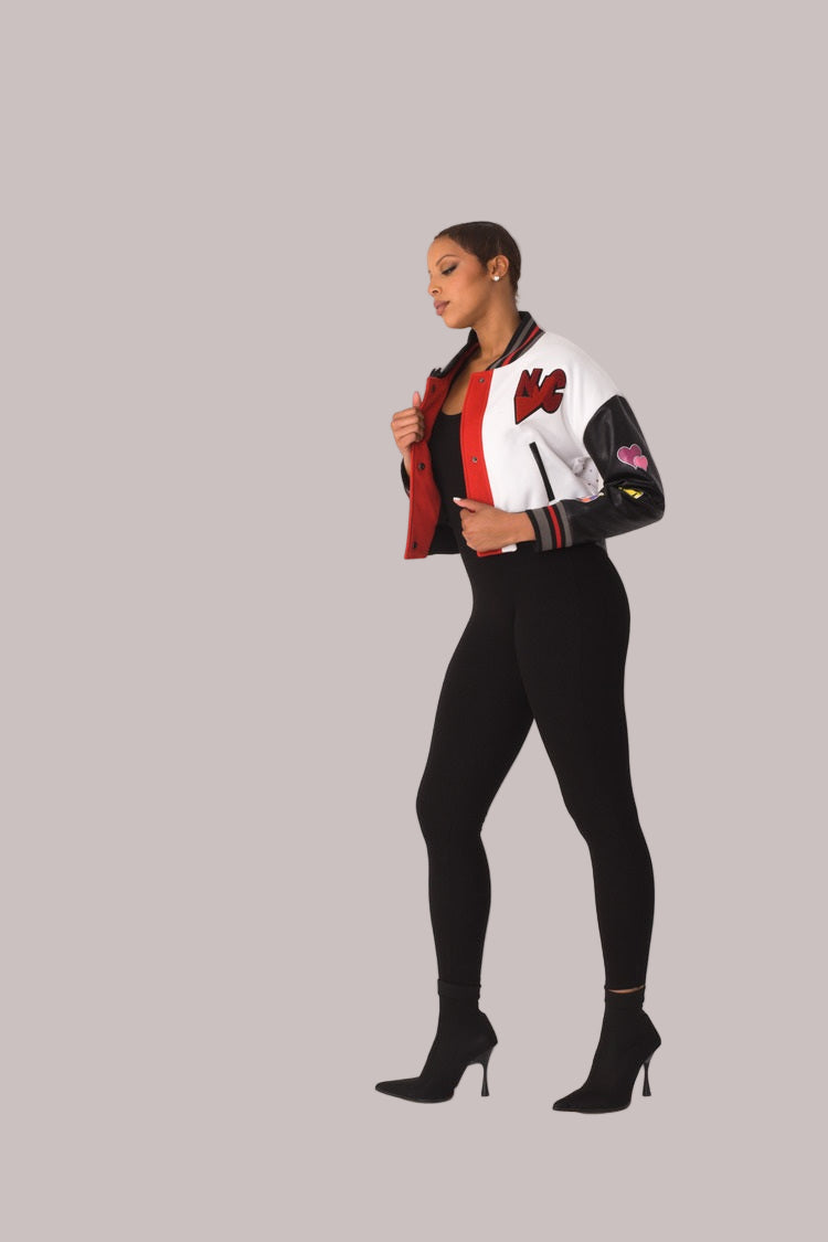 Betty Boop varsity crop jacket style 82236 in white and black shown from the back in a standing pose highlighting the graphic back detail and cropped length by For Her NYC