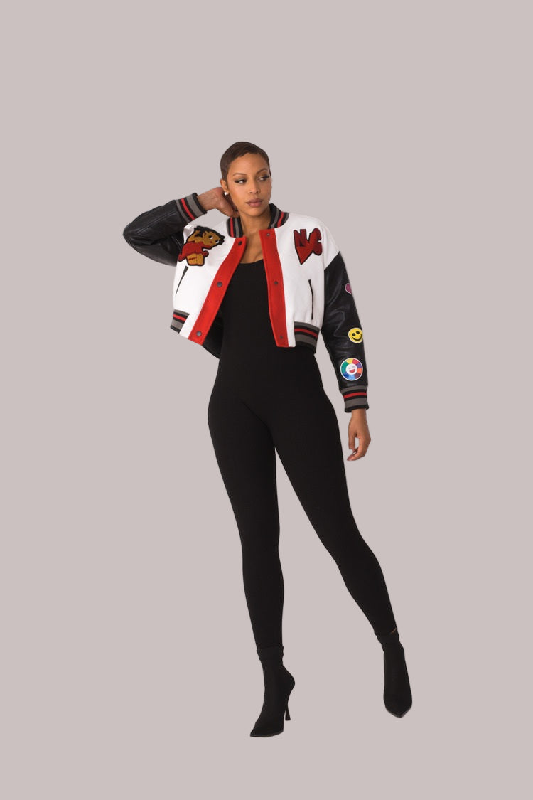 Betty Boop varsity crop jacket style 82236 in white and black shown in a walking forward pose emphasizing movement and sporty cropped silhouette by For Her NYC