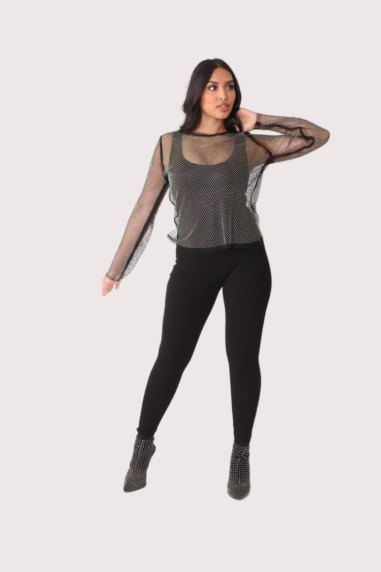 Crystal mesh long sleeve top style 82249 in black shown with arm movement in a standing pose highlighting sleeve transparency and rhinestone embellishment by For Her NYC