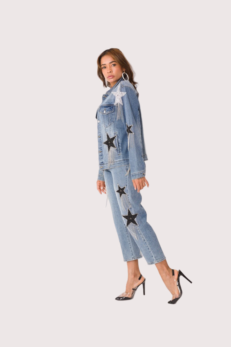 Stardust Dreams denim jacket style 82331 shown from the side in a walking pose showcasing movement, chain fringe detail, and relaxed denim fit by For Her NYC