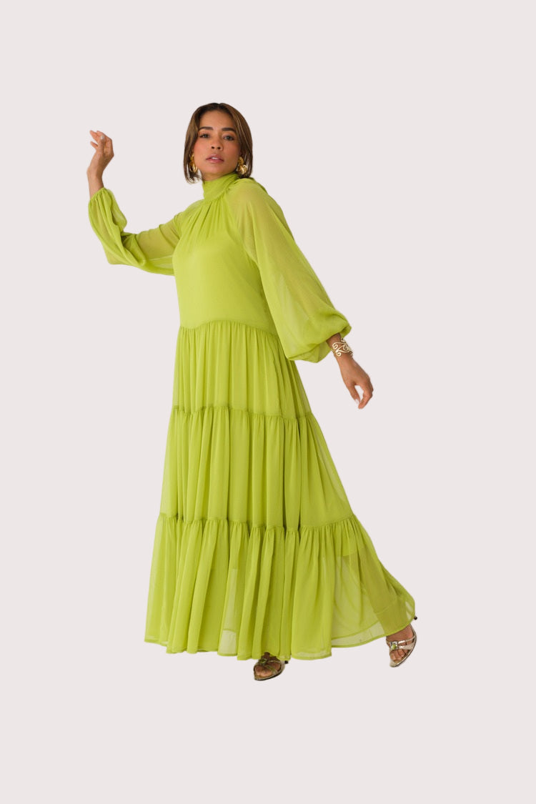 Chartreuse Dream tiered maxi dress style 82348 in lemon grass shown with arm raised in a light motion pose emphasizing the airy movement and romantic drape by For Her NYC