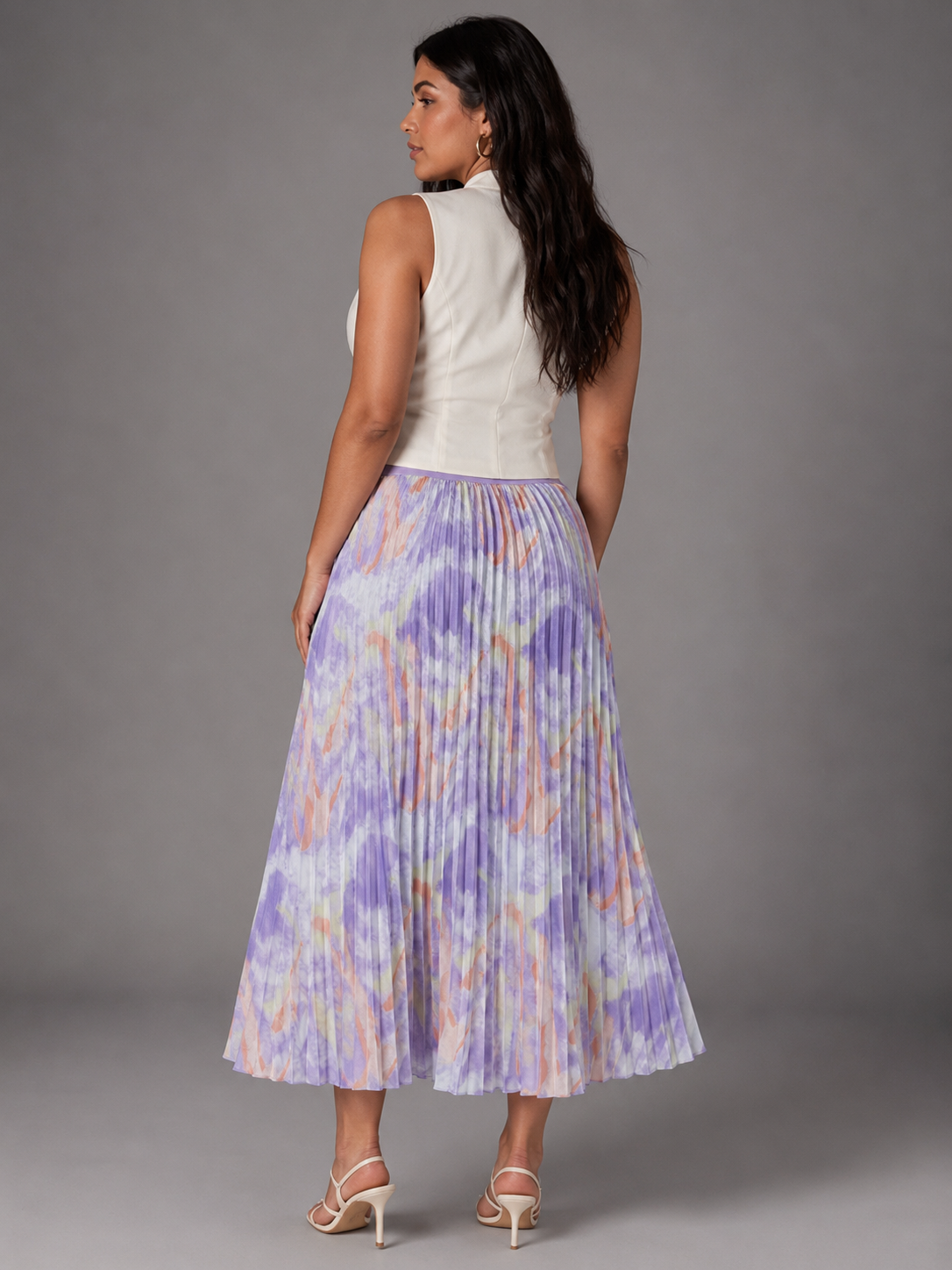 Watercolor print pleated maxi skirt in purple multi, model standing back view, For Her NYC