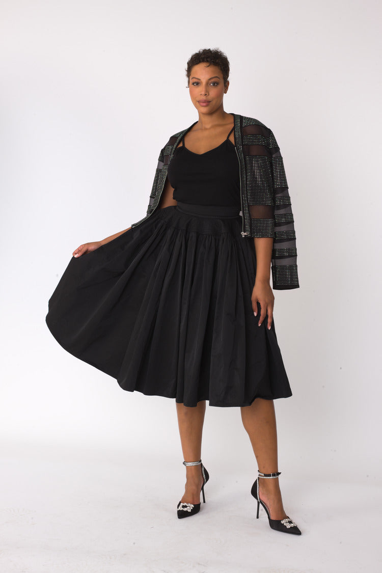 Black full circle taffeta skirt styled with black top and jacket, model walking forward, For Her NYC