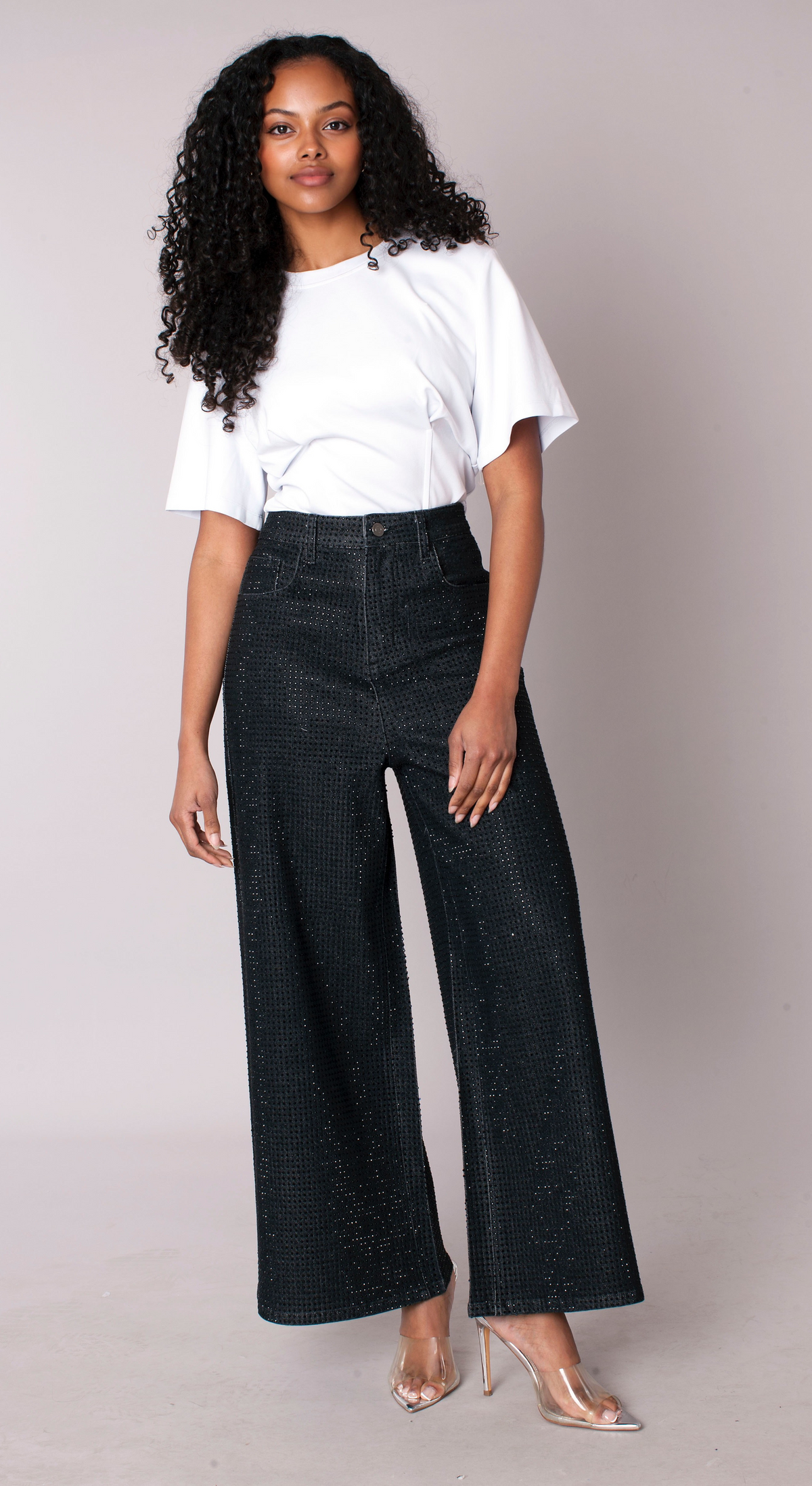 Midnight sparkle wide-leg trousers with subtle allover shimmer and elongated silhouette, model standing front view styled with white top For Her NYC