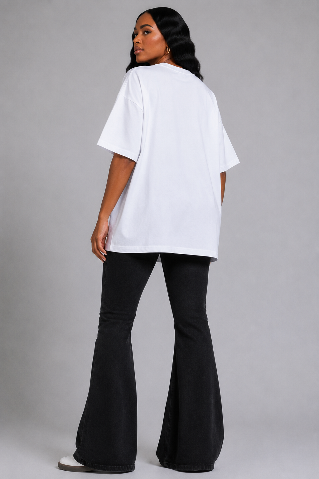 White/Multi graphic tee featuring vibrant electric portrait artwork with rhinestone detailing, model standing front view wearing tall boots For Her NYC