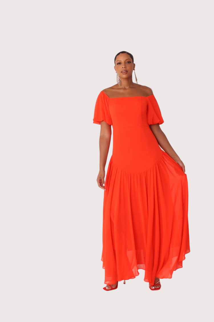 Red off-shoulder maxi dress shown front standing view, dramatic ruffle neckline and flowing skirt, For Her NYC