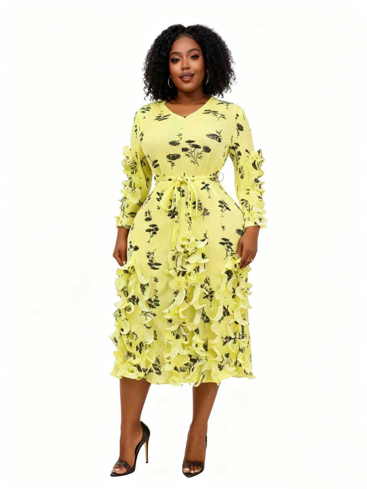 Woman wearing a yellow floral midi dress with ruffle trim, long sleeves, and a tie waist, styled with black heels — For Her NYC