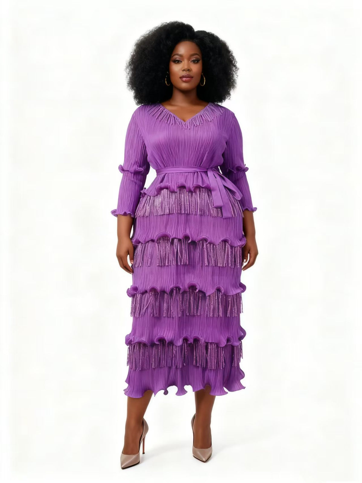 Woman wearing a purple pleated midi dress with tiered fringe layers, ruffle trim, and a defined waist, styled with heels — For Her NYC