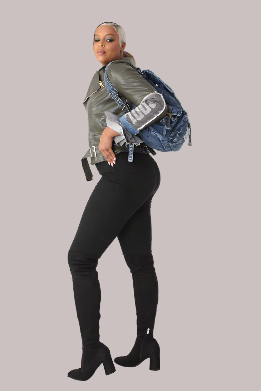 Angled side view of army green faux leather moto jacket showing denim patchwork sleeves and rhinestone COOL detail.