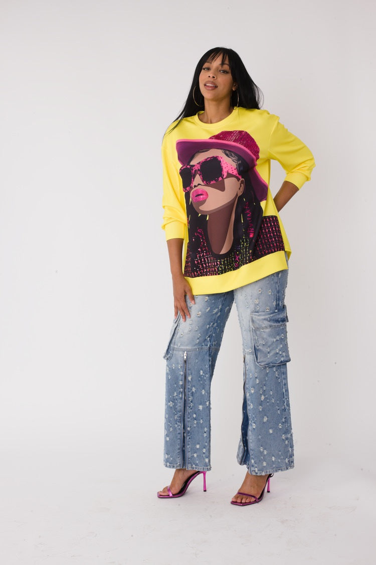 Model wearing the yellow artistic portrait graphic long sleeve t shirt standing front facing, featuring bold portrait print with yellow hat and relaxed fit by For Her NYC