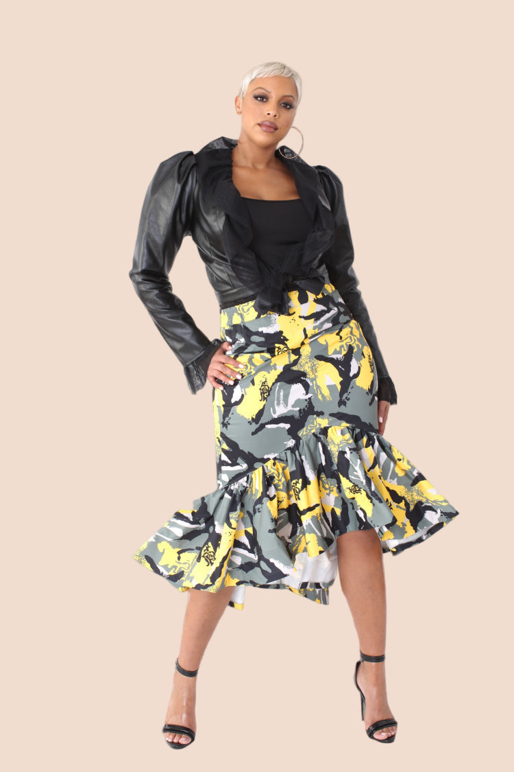 Front view of black faux leather cropped jacket featuring puffed shoulders, wrap design, and sheer ruffle accents styled with a floral skirt.