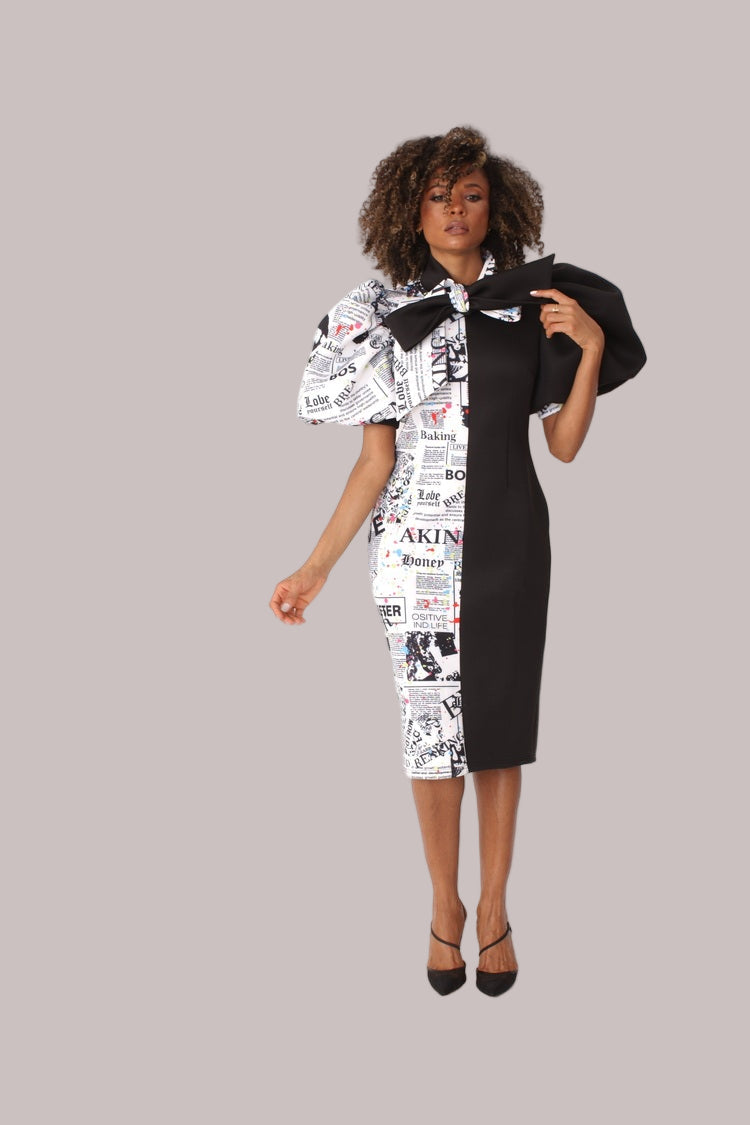 Model wearing black print puff sleeve midi dress with bow tie collar, front-facing hero pose highlighting bold graphic print and structured silhouette by For Her NYC