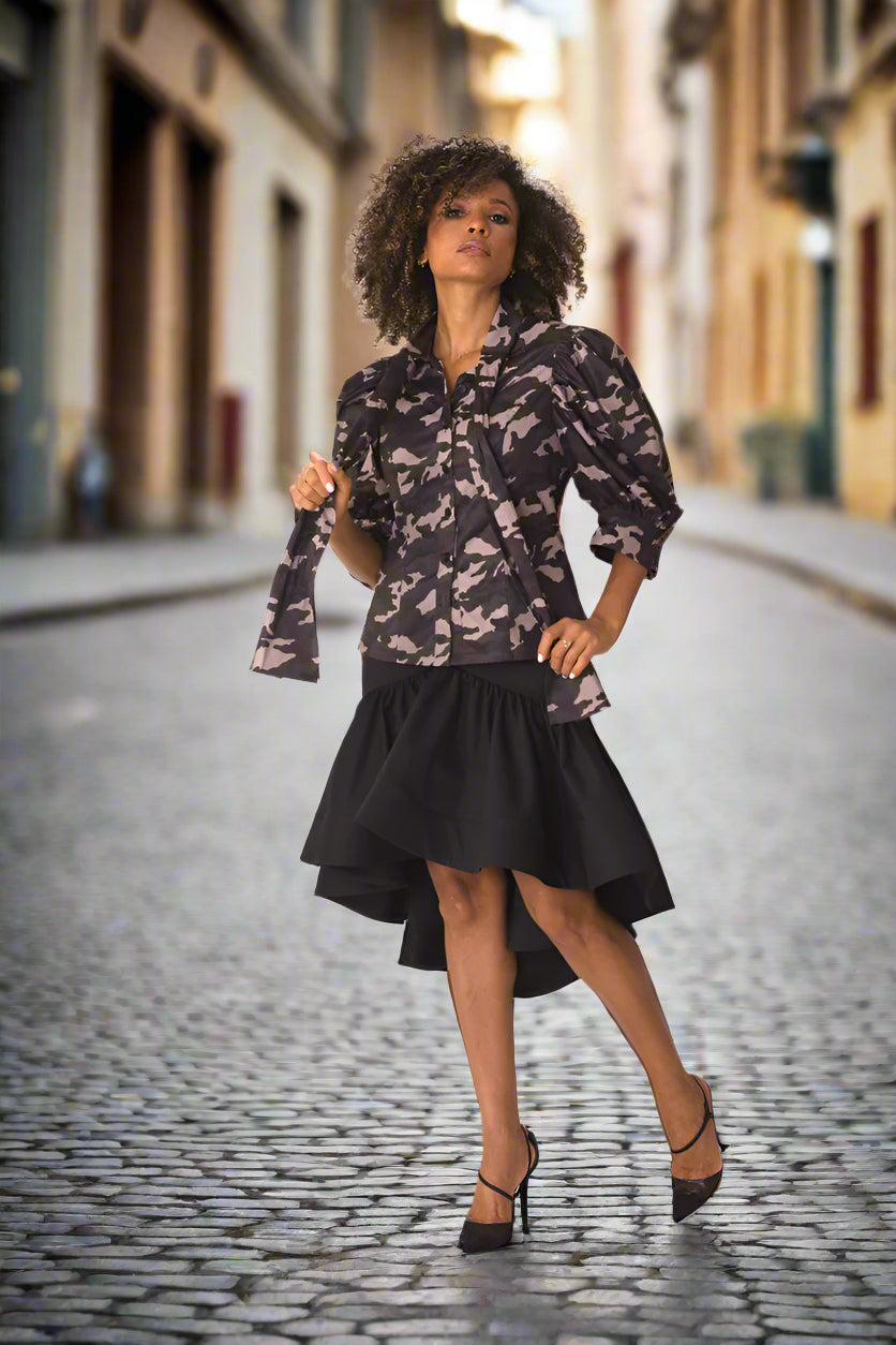 Model wearing black ruffle midi skirt, movement pose emphasizing dramatic ruffle flow and modern styling by For Her NYC