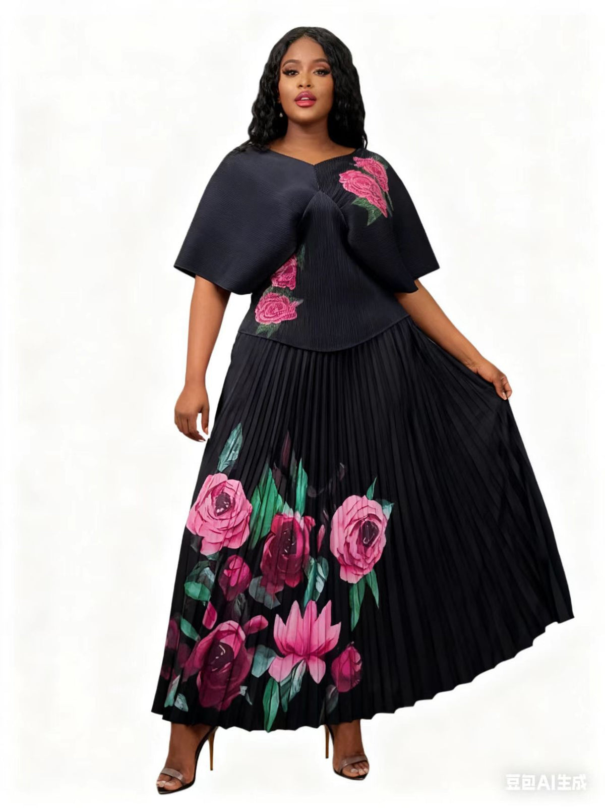 Front view of model wearing a black pleated skirt set with vibrant floral accents and flowing skirt, For Her NYC