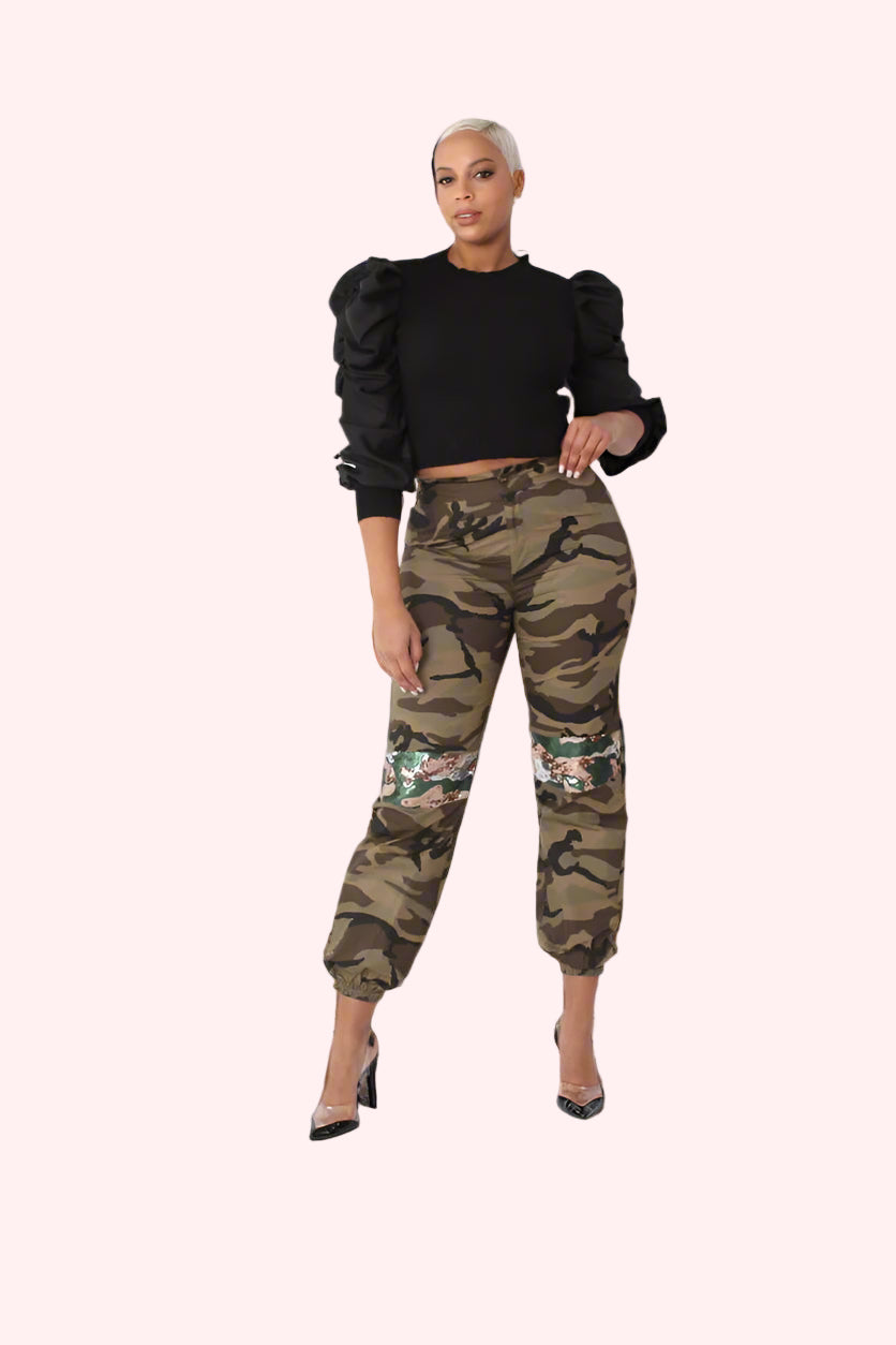 Front full view of camo sequin joggers with sequin accents along the legs, relaxed fit with elastic hems styled casually by For Her NYC
