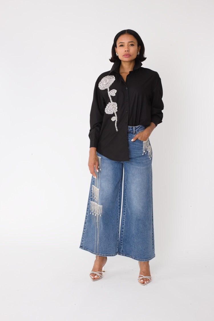 Model wearing the denim crystal cascade wide leg jeans standing front facing, showcasing cascading rhinestone embellishments and high waisted silhouette by For Her NYC