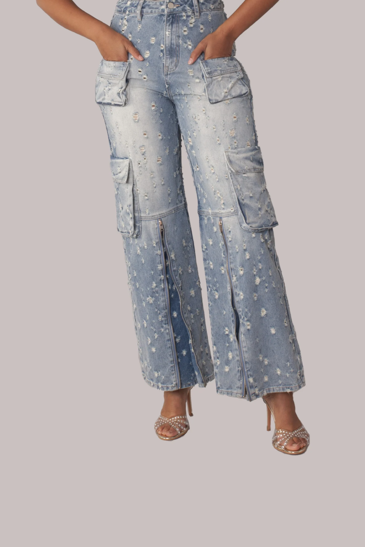 Distressed denim cargo jeans close-up showing distressing and wide leg hem detail, For Her NYC