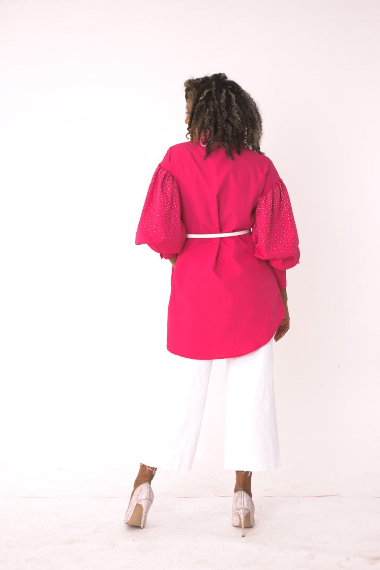 Back view of the fuchsia embellished long sleeve rhinestone shirt styled with white pants – For Her NYC