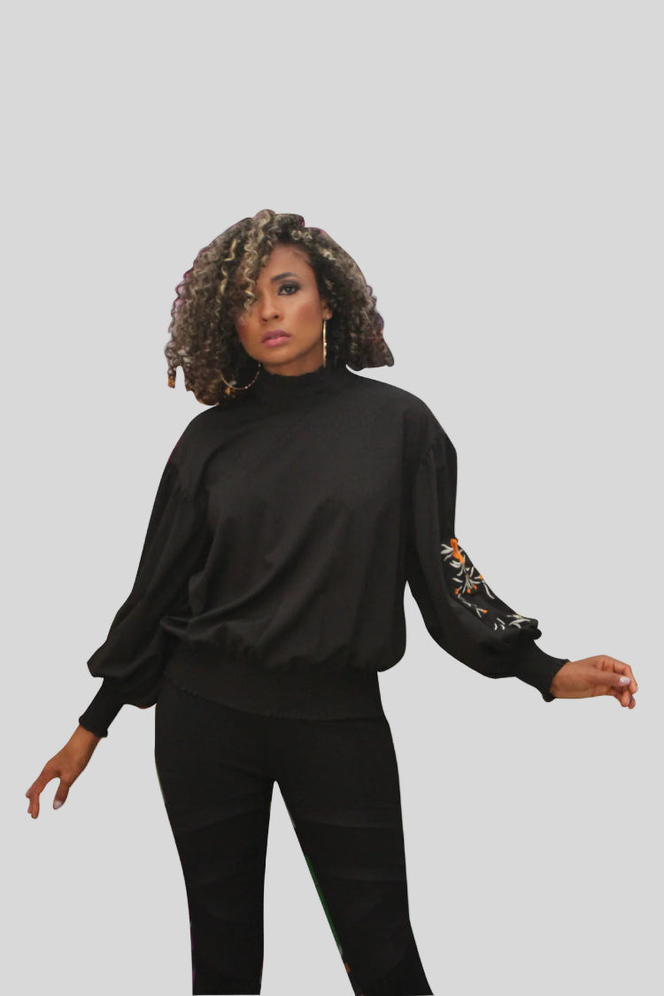 Front view of black balloon sleeve blouse with floral embroidered sleeves and elastic hem — For Her NYC.