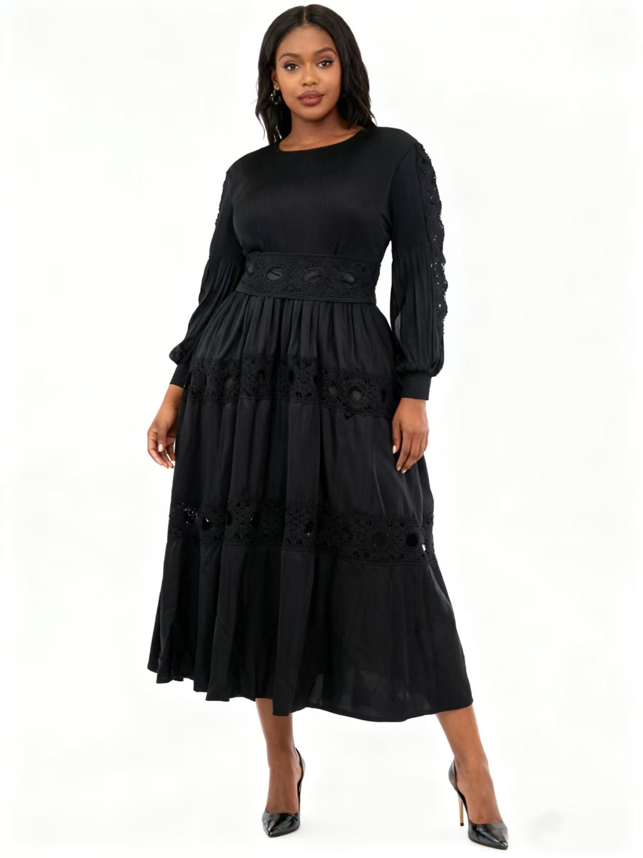 Front view of model wearing a black long sleeve tiered midi dress with lace inset accents and flowing silhouette, For Her NYC