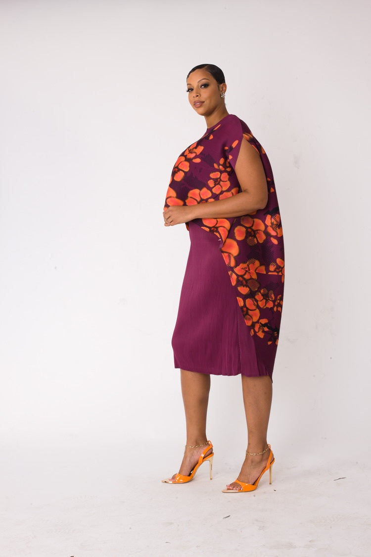Three quarter angled view of model wearing the red and purple floral overlay shift dress emphasizing artistic drape and fluid movement by For Her NYC