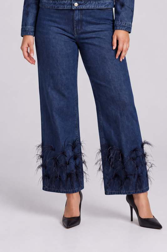 detail view of a model wearing the dark-wash For Her NYC Feather Trim Wide Leg Jeans - 82304, highlighting the wide legs and feather-embellished hems