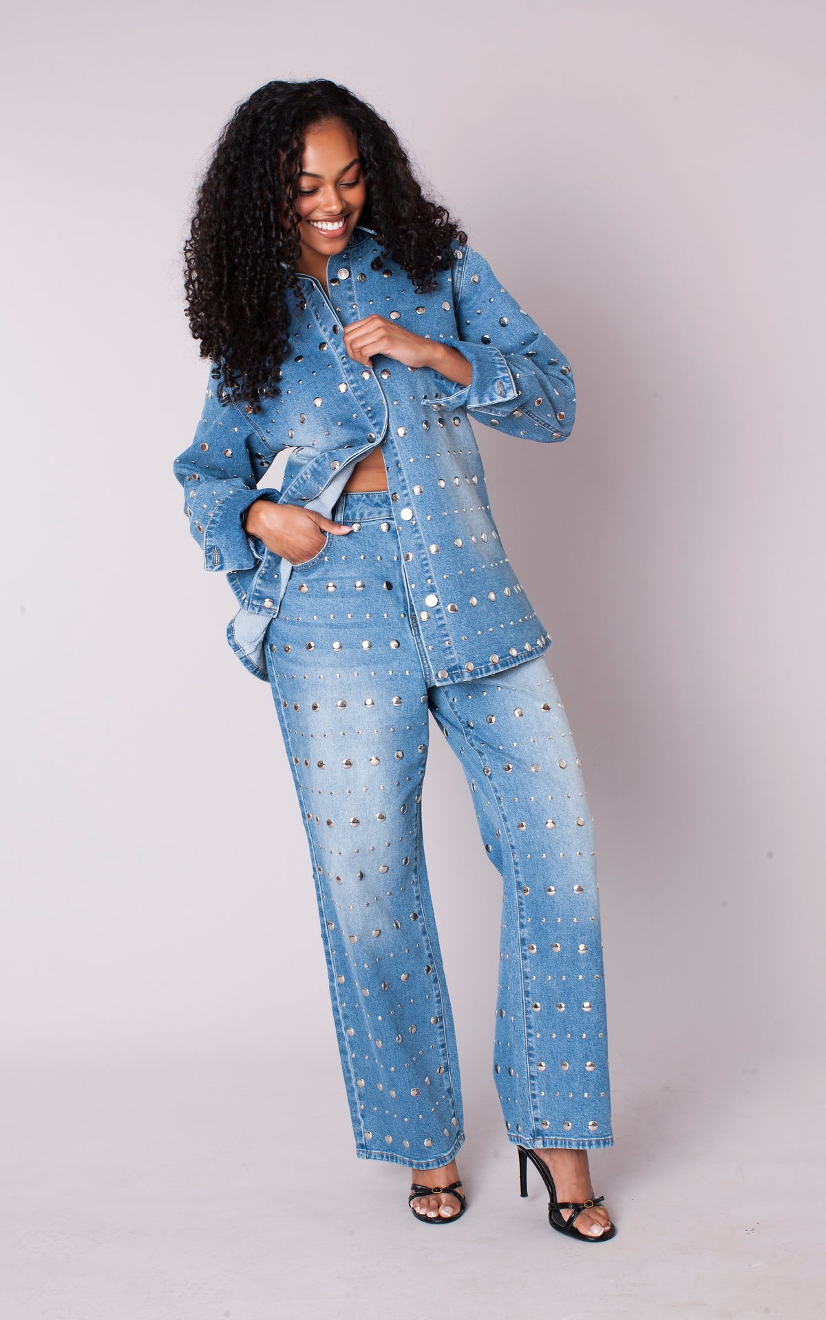 Front view of a model wearing the light-wash For Her NYC Mirror Stud Wide-Leg Denim Jeans - 83037 with mixed-size silver stud embellishments