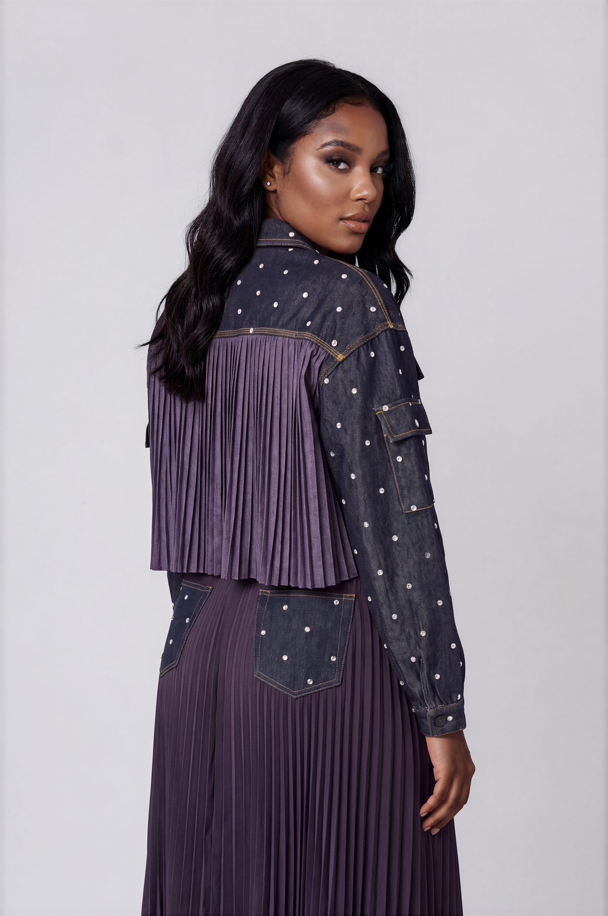 Back detail of a plus size model wearing the dark-wash For Her NYC Embellished Cropped Denim Jacket - 82962, highlighting the pleated back panel and rhinestone sleeves