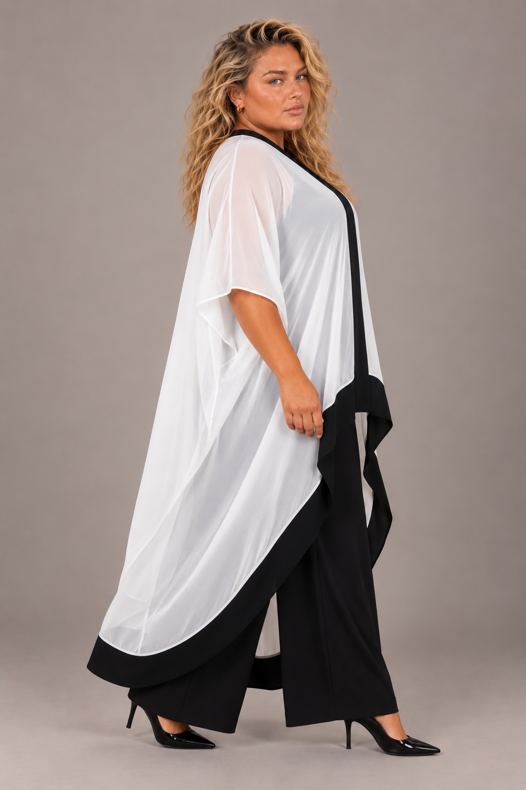 Plus size model wearing the For Her NYC Flowy High-Low Chiffon Pant Set S0281W, side view with white chiffon overlay and black wide-leg pants.