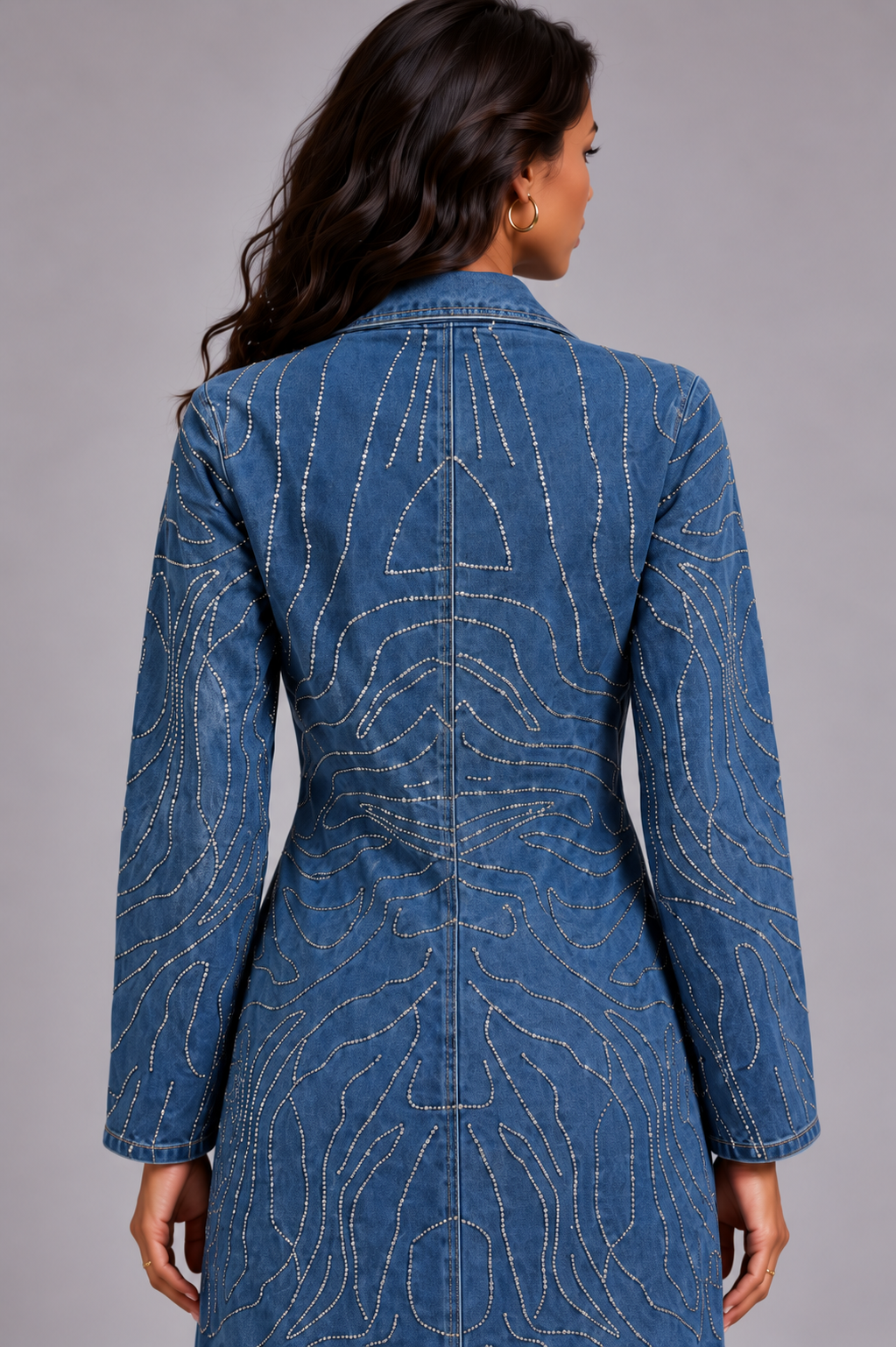 Back detail of a model wearing the medium-wash For Her NYC Rhinestone Swirl Denim Duster Coat - 83070 with allover curved rhinestone detailing
