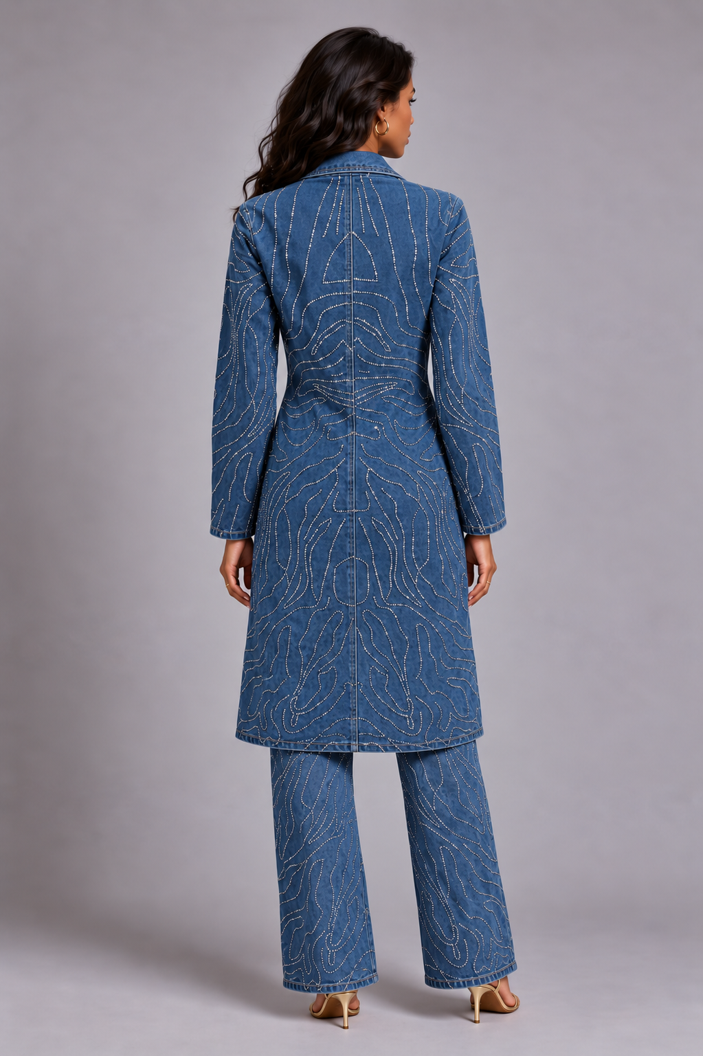 Back view of a model wearing the medium-wash For Her NYC Rhinestone Swirl Denim Duster Coat - 83070 with matching rhinestone denim jeans